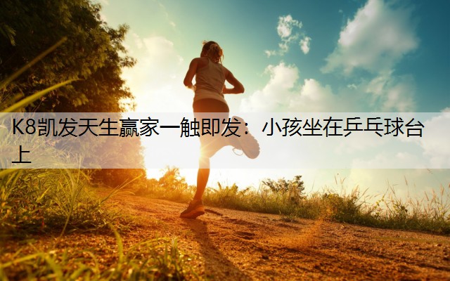 小孩坐在乒乓球台上